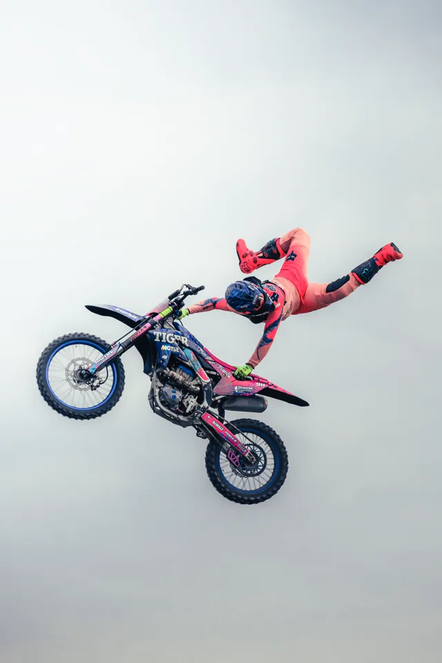 ZAPSA extending away from his motorcycle during a freestyle jump