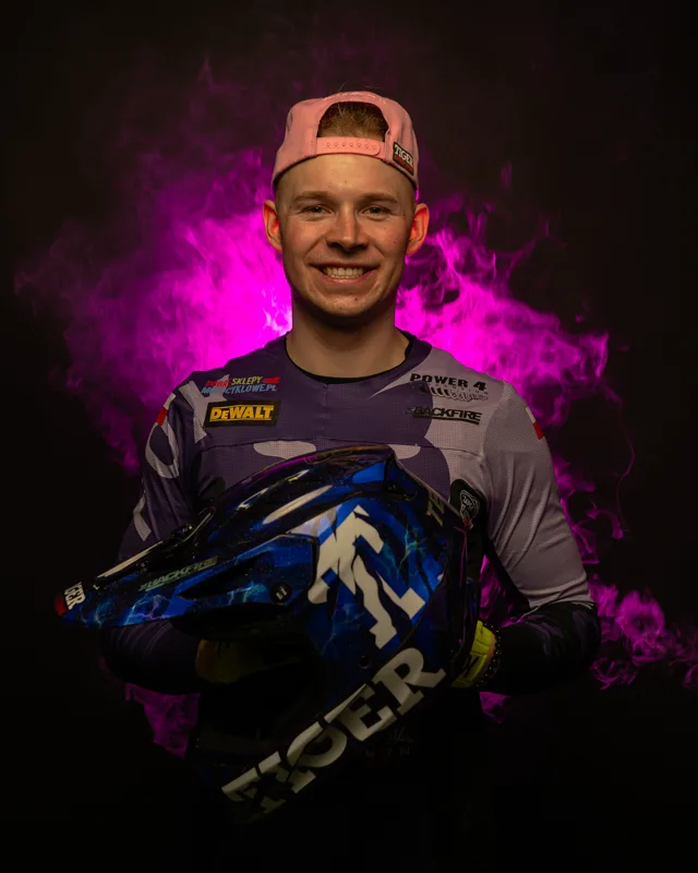 Mikołaj ZAPSA Tempka smiling with his helmet against purple smoke